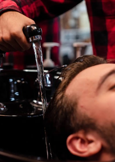 Tesoura e pente em uso durante corte masculino em Campinas