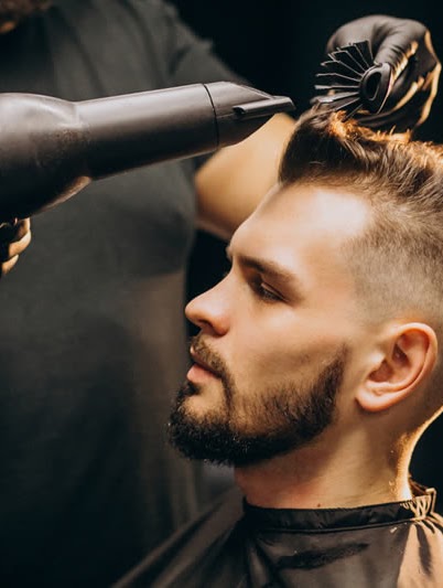 Barbeiro alinhando penteado em atendimento premium no Cambui